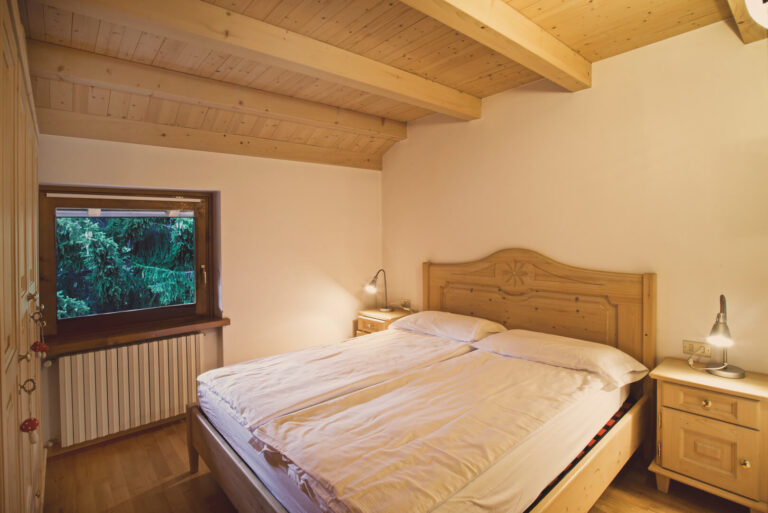 Camera matrimoniale in stile alpino e vista sulle Alpi dello chalet